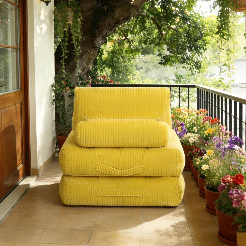 Front view of the yellow corduroy bean bag couch on a patio.