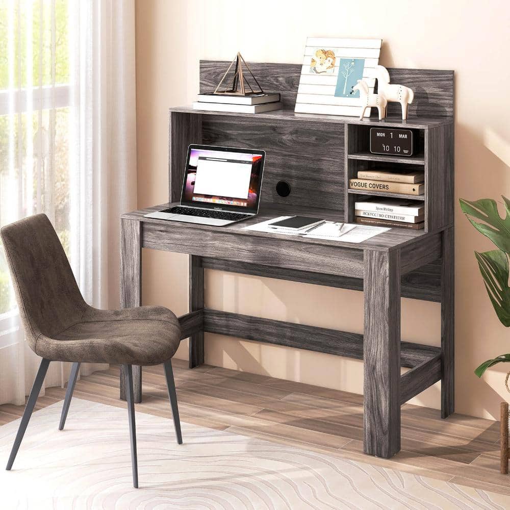Wooden computer desk with an office chair in a bright room.