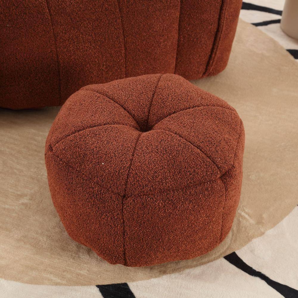 Close-up of the tufted top of a red brown velvet ottoman.