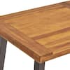 Teak wood outdoor dining table in a styled setting.