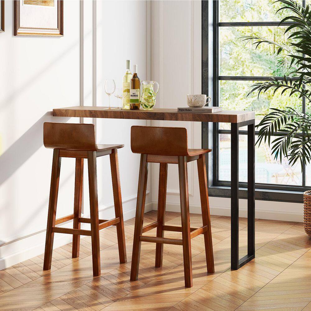 Two wooden bar stools placed at a tall wooden table.