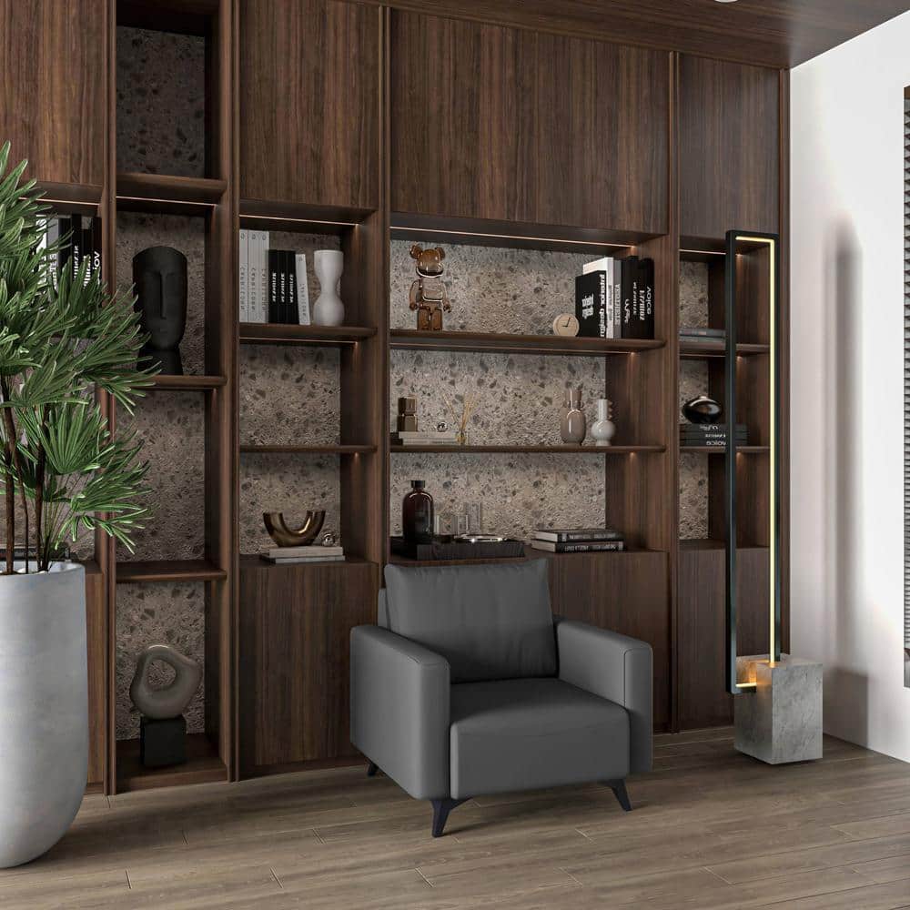 Grey armchair in a room with dark wood shelving.