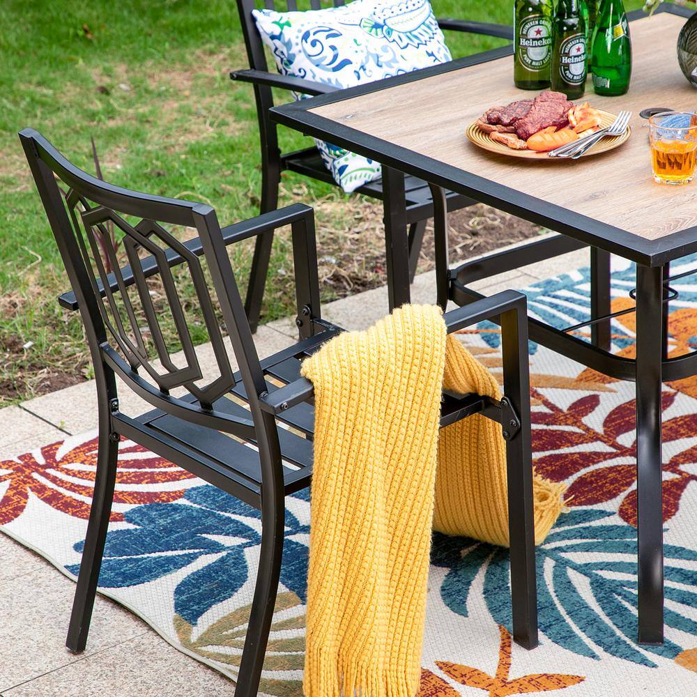 Outdoor patio dining set with patterned cushions on a rug.