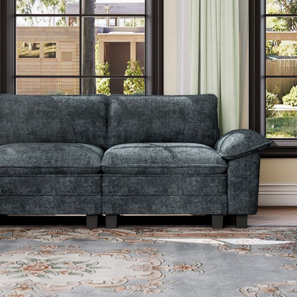 Dark gray sectional sofa with wide armrest in a living room.