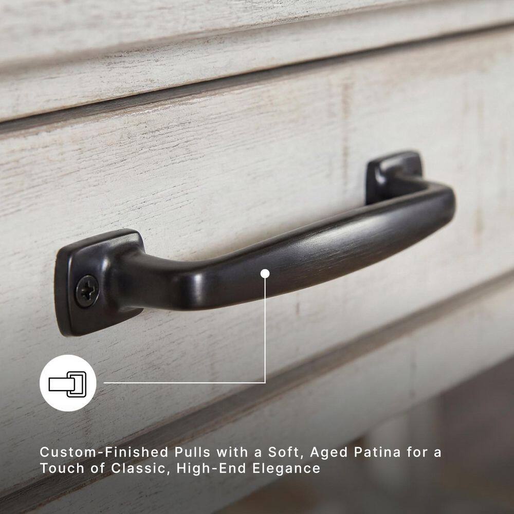 Close-up of the dark metal drawer pull on the white distressed desk.