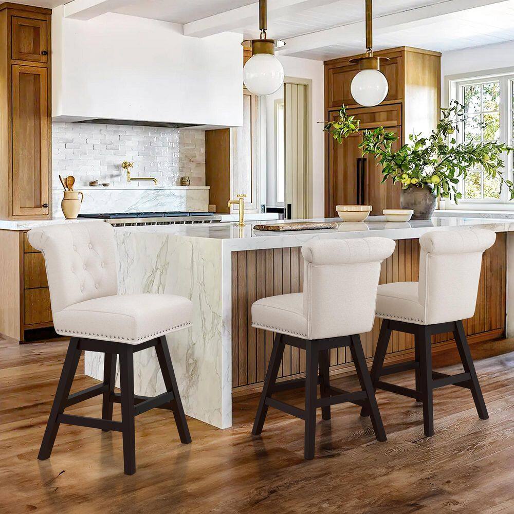Three beige bar stools at a kitchen counter in a bright room.