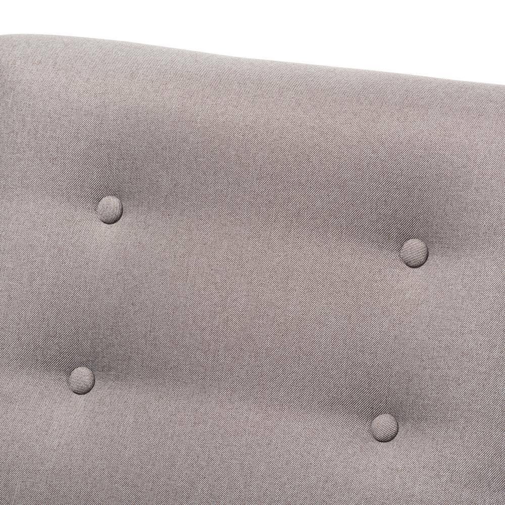 Close-up detail of the button tufting on the gray fabric chair.