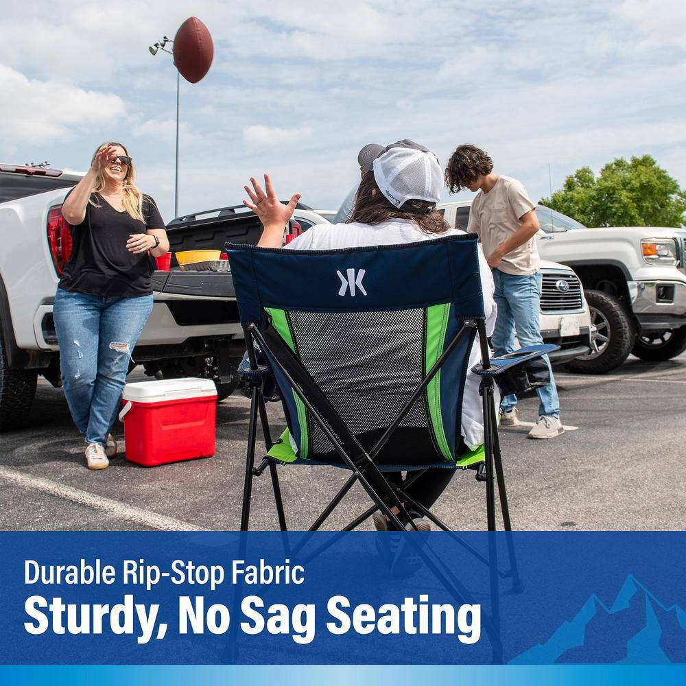 A person sitting in a Seattle Seahawks camping chair in a parking lot.