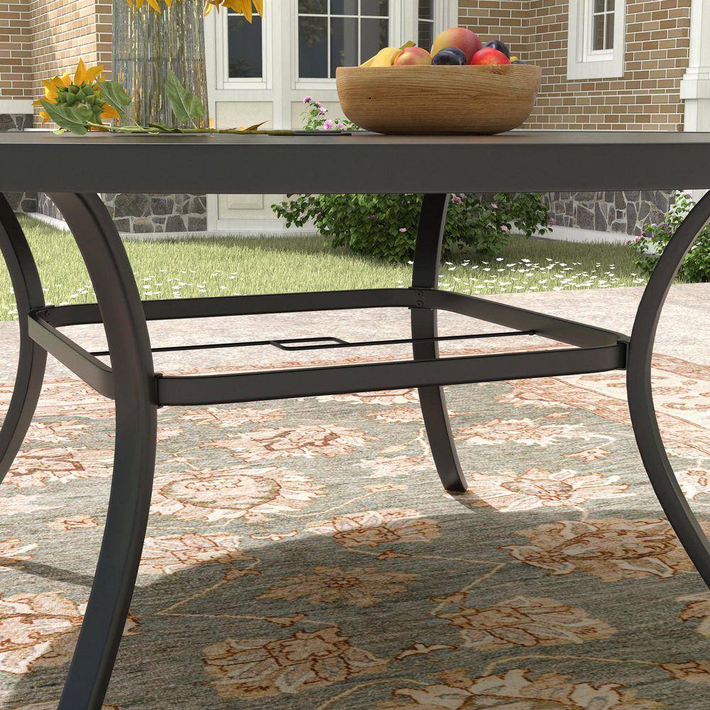 Close-up of the curved metal legs and support frame of a dark grey outdoor table.