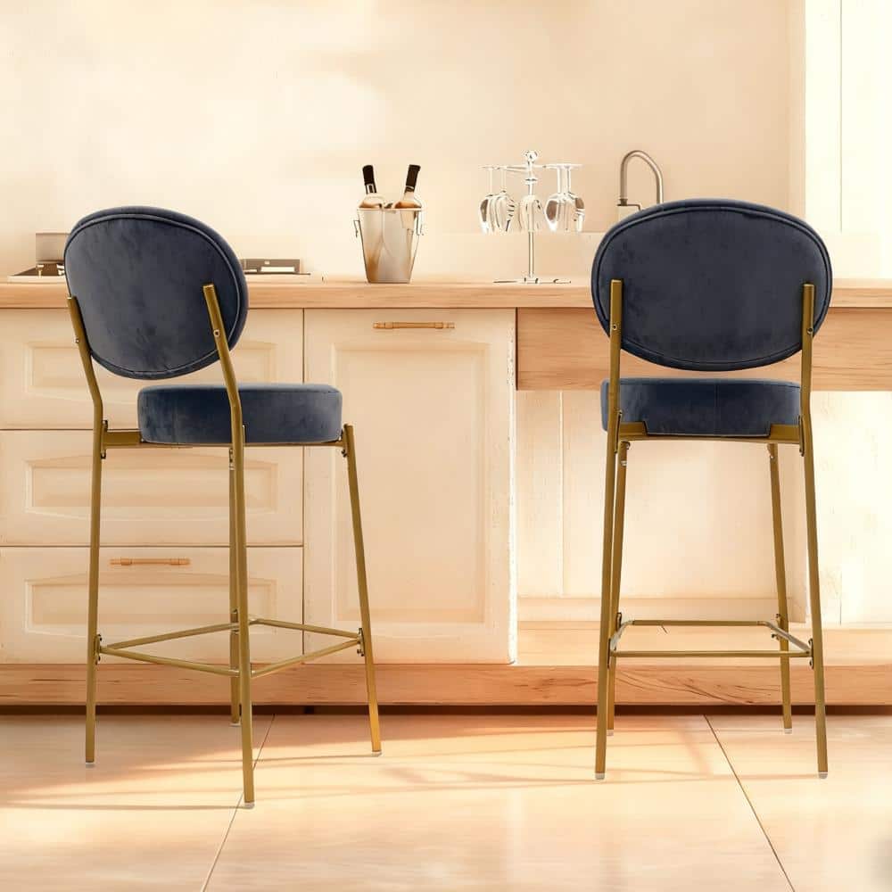 Two navy blue velvet bar stools with gold metal legs.