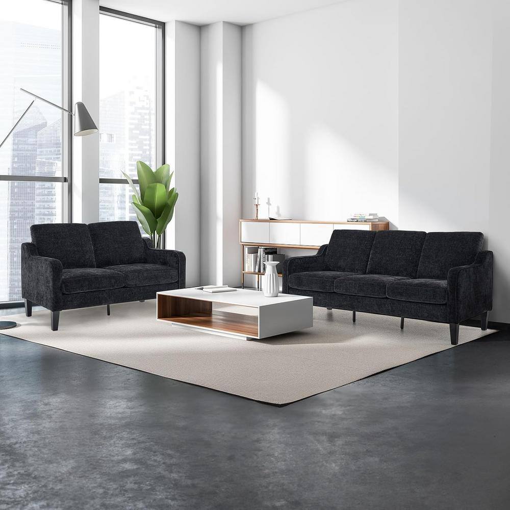 Two black sofas in a modern living room setting.