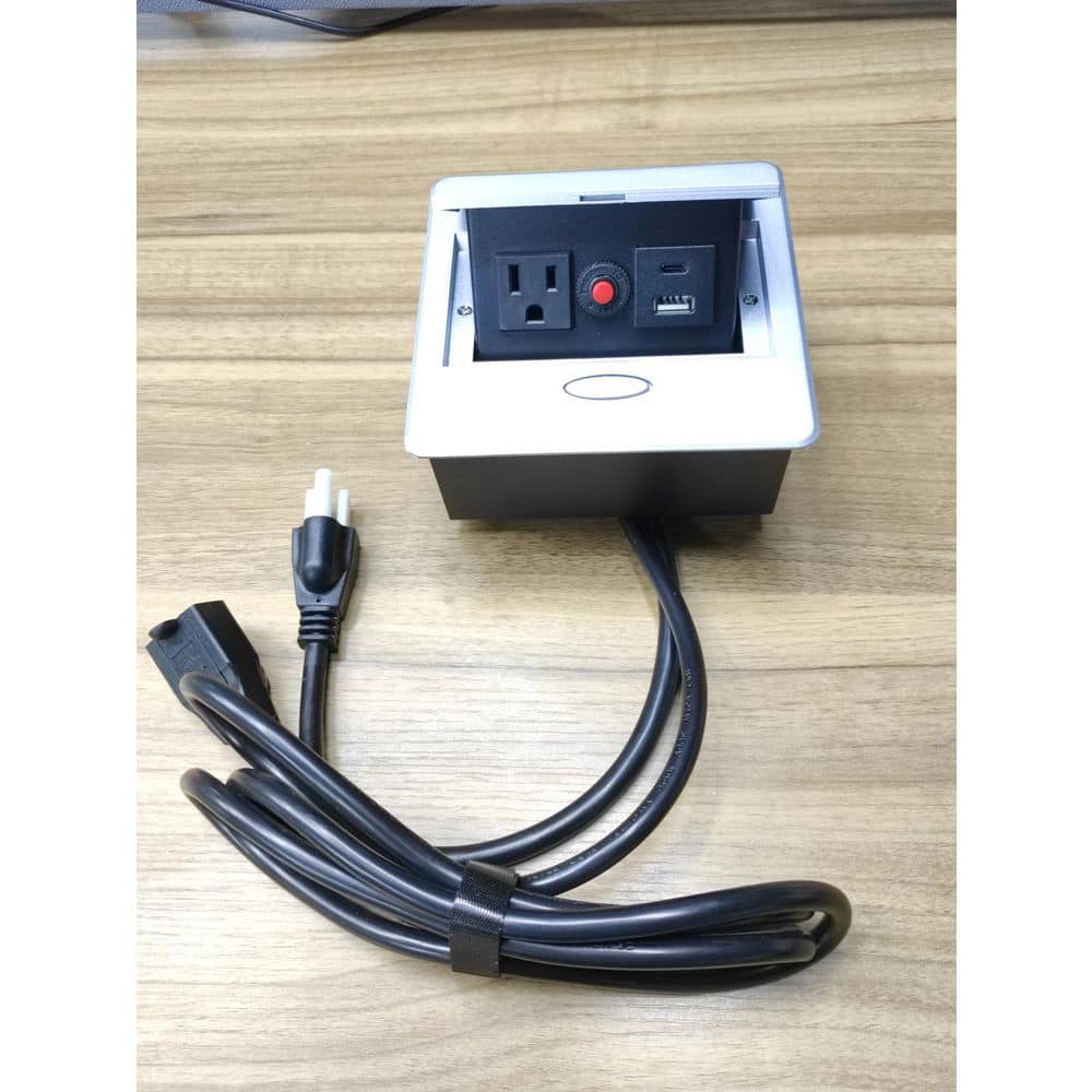 Close-up of an integrated power strip with an outlet, USB port, and power cord.