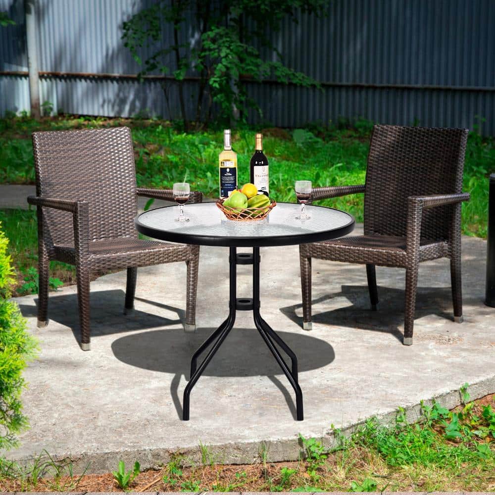 Patio dining table with wicker chairs outdoors.
