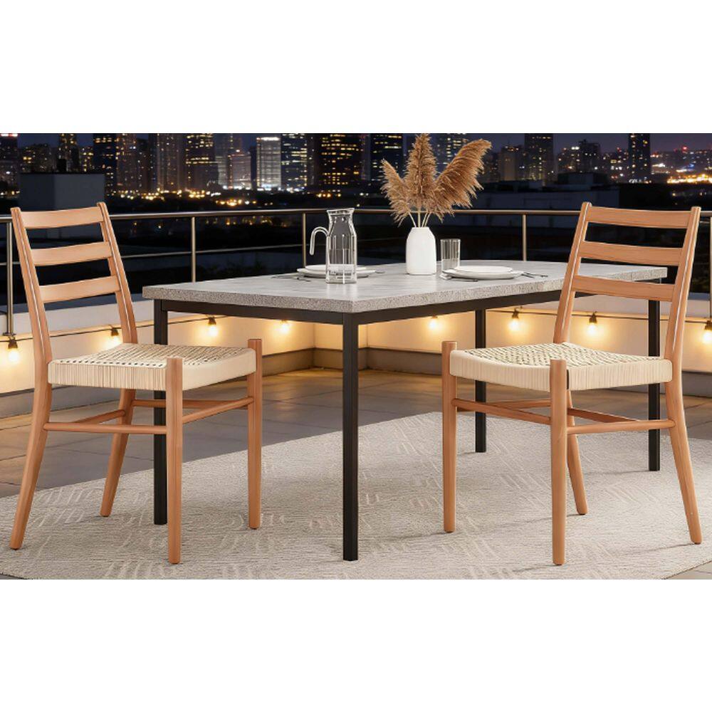 Two natural wood dining chairs with woven seats on a balcony overlooking a city skyline.