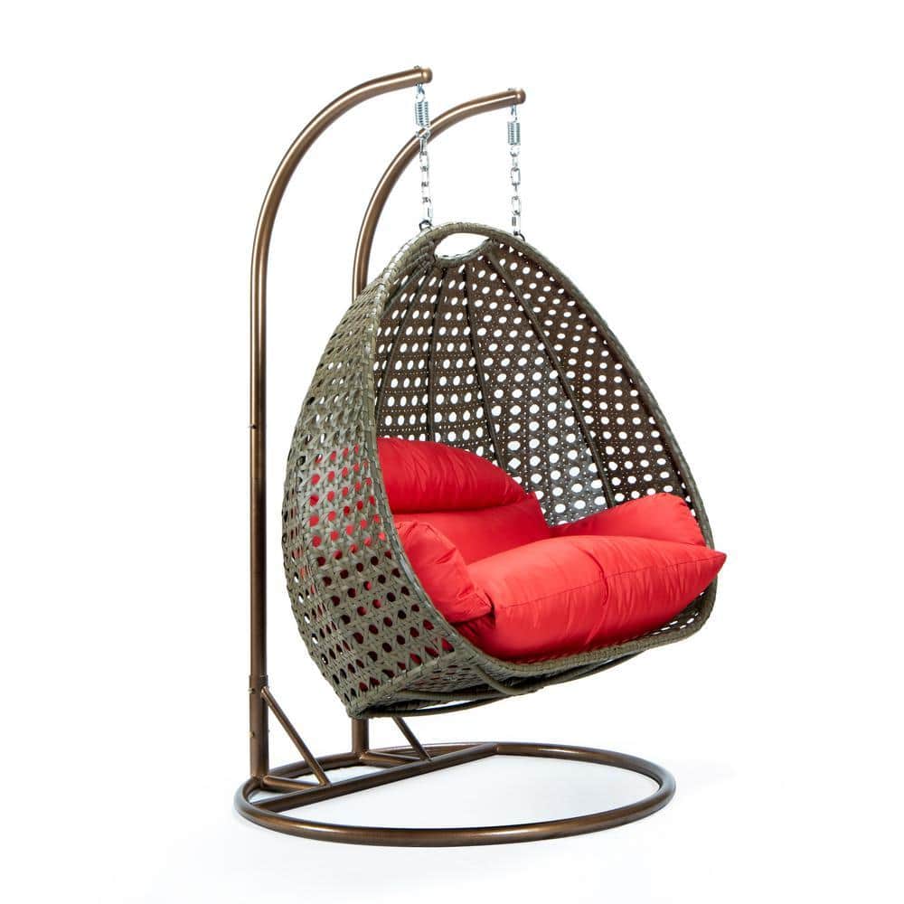 Outdoor egg swing chair with red cushions on a wooden deck.