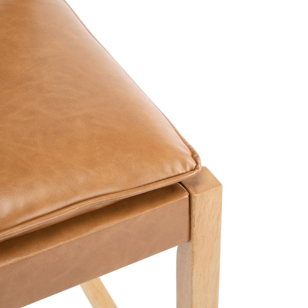 Close-up of the brown PU leather seat of a wooden bar stool.