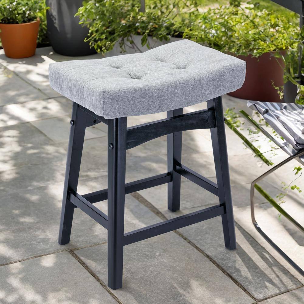 Black metal dining chair with gray cushion in an outdoor patio setting.