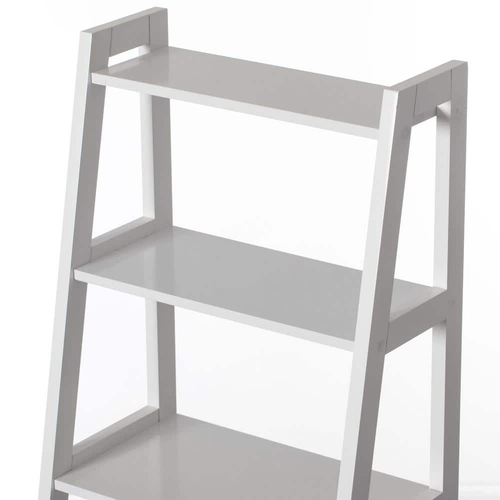 Close-up view of the white shelves of a ladder bookcase.
