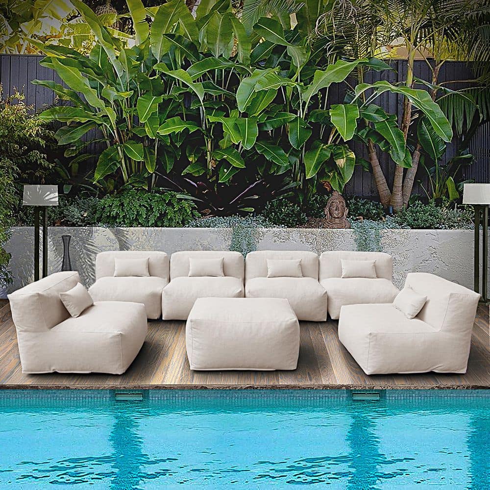 Light beige modular outdoor sectional sofa set by a swimming pool.