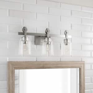 Knollwood 22-3/4 in. 3-Light Brushed Nickel Industrial Vanity Light with Vintage Accents and Clear Glass Shades