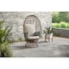 Brown Wicker Outdoor Swivel Patio Egg Lounge Chair with Beige Cushions and Black/Cream Pattern Pillows