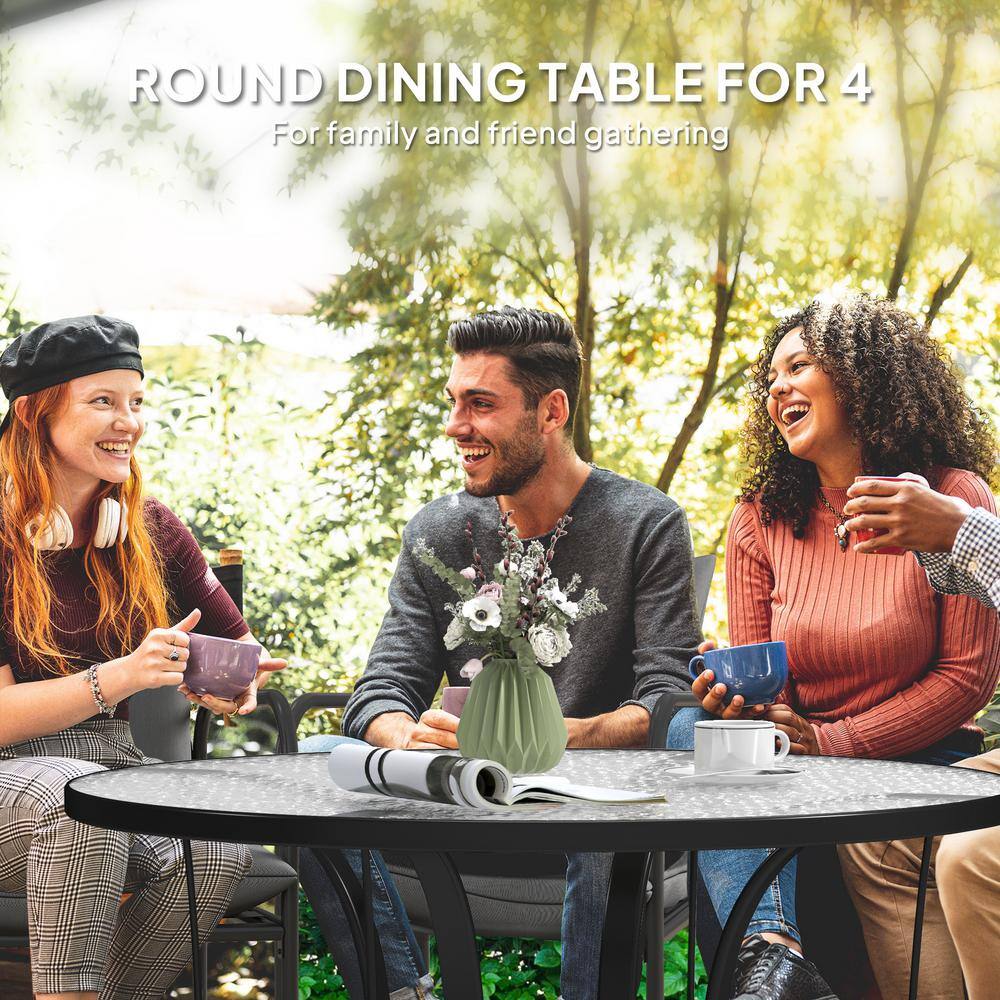 Three people sitting around a round patio table in a garden.