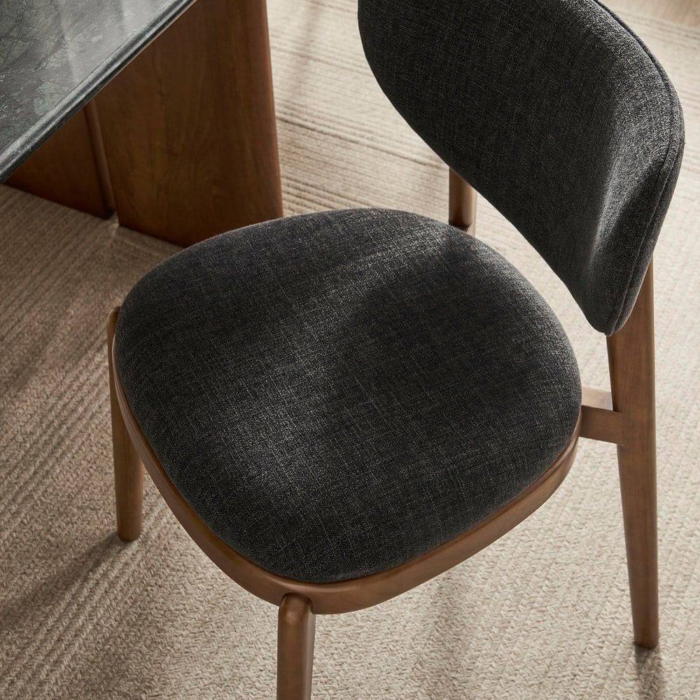 Close-up view of the ebony slub weave fabric on a dining chair seat.