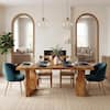 A brown solid wood dining table with sculptural legs in a modern dining room.
