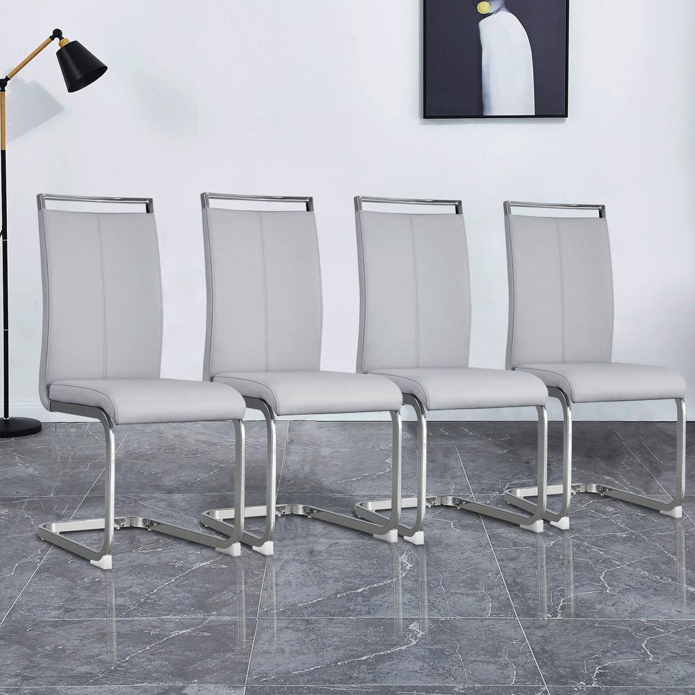 Set of four light gray PU leather dining chairs with chrome cantilever frames.