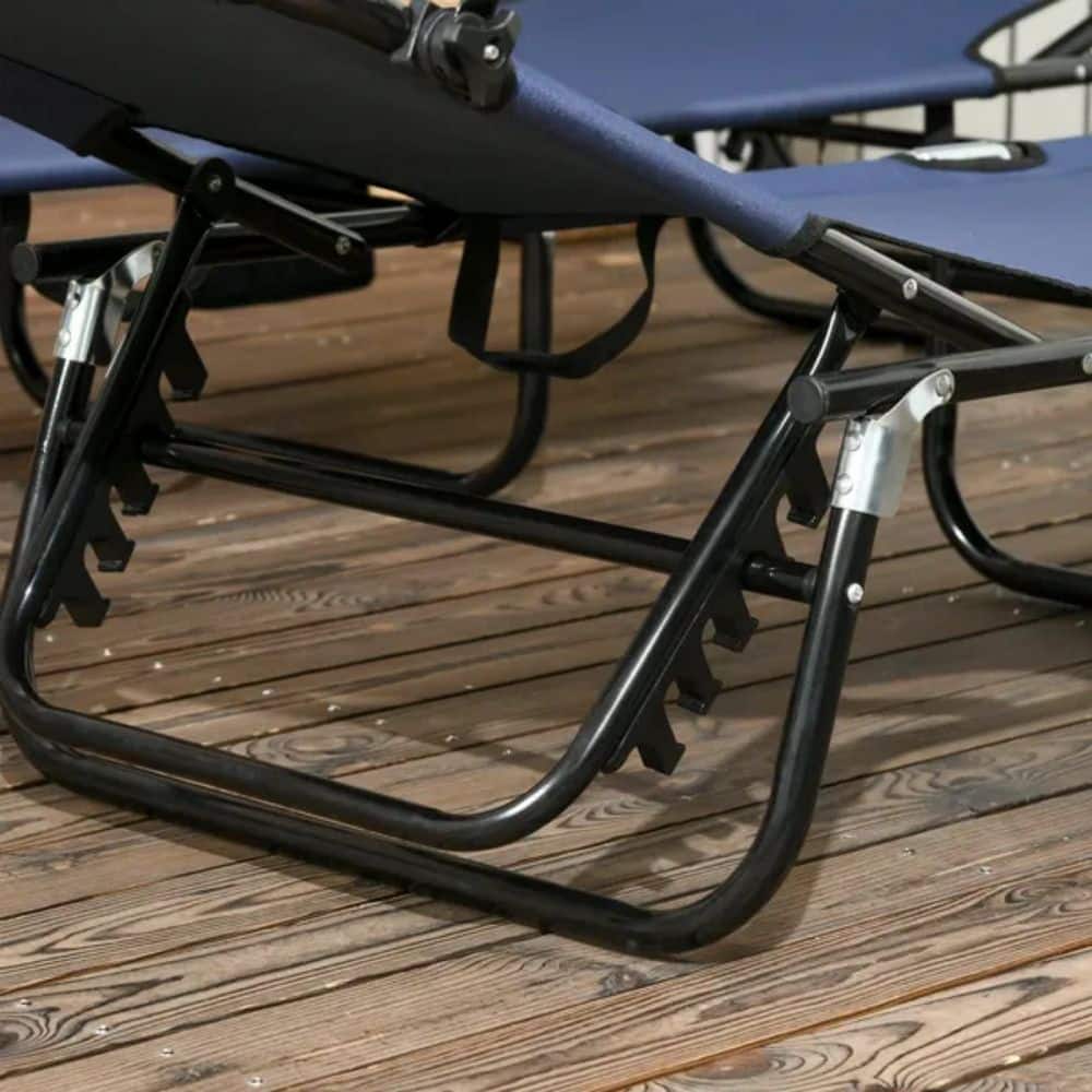 Two dark blue foldable chaise lounges on a wooden deck.