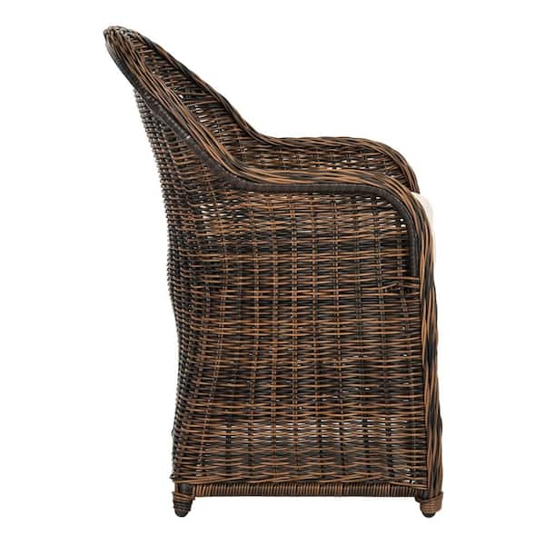 Wicker chair with cushions and a plaid close-up on background of