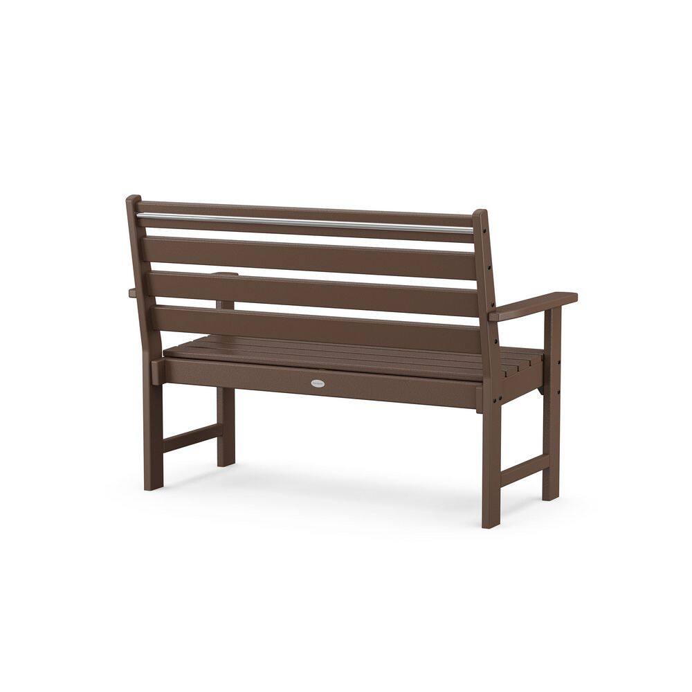 Three-quarter rear view of a mahogany plastic outdoor bench.