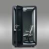 Office sound pod booth with open door showing white desk and gray chair.
