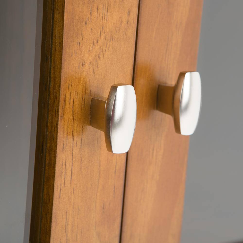 Close-up of the silver oval knobs on the storage cabinet.