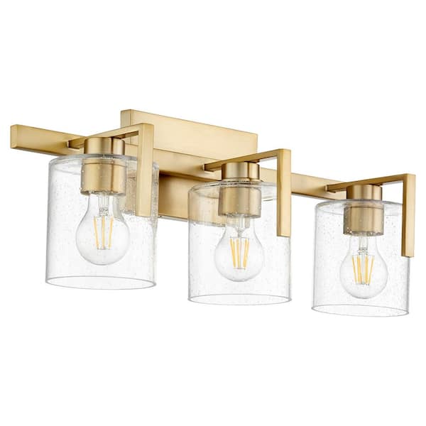 Quorum International 3-Light -100-Watt Medium base lamp Light Vanity 22 in. Width with 3 Clear Seeded glasses Aged Brass