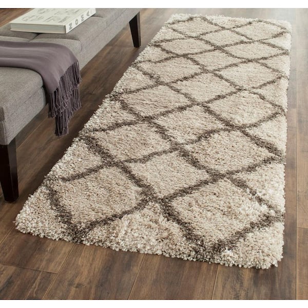 https://images.thdstatic.com/productImages/a0d0b65e-cc29-43ee-b973-924290b030b0/svn/taupe-gray-safavieh-area-rugs-sgb489d-27-64_600.jpg