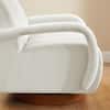 Close-up of the white bouclé fabric and curved arm of the swivel chair.