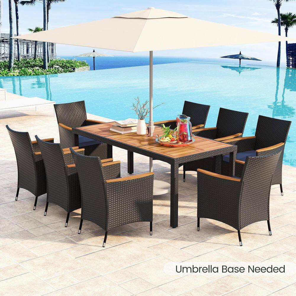 Wicker outdoor dining set with a large white umbrella by a swimming pool.