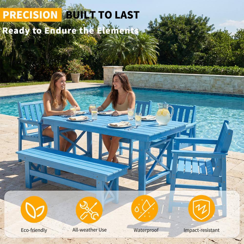 Four blue Adirondack chairs around a wooden table by a pool.