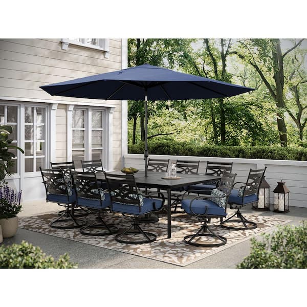 Hanover Montclair 11-Piece Steel Outdoor Dining Set with Navy Blue Cushions, 10 Swivel Rockers, 60x84 in. Table and Umbrella