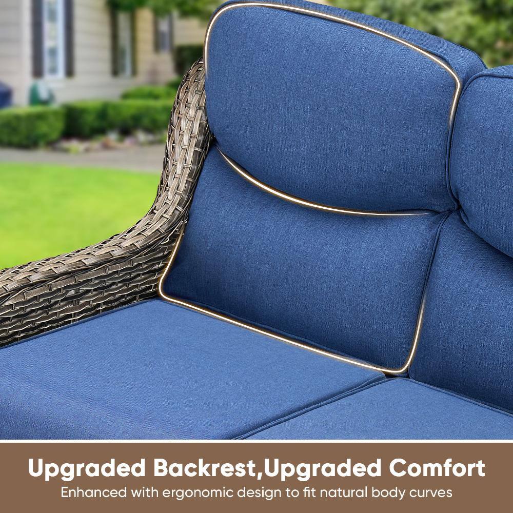Close-up of the blue cushion and gray wicker armrest of an outdoor sofa.