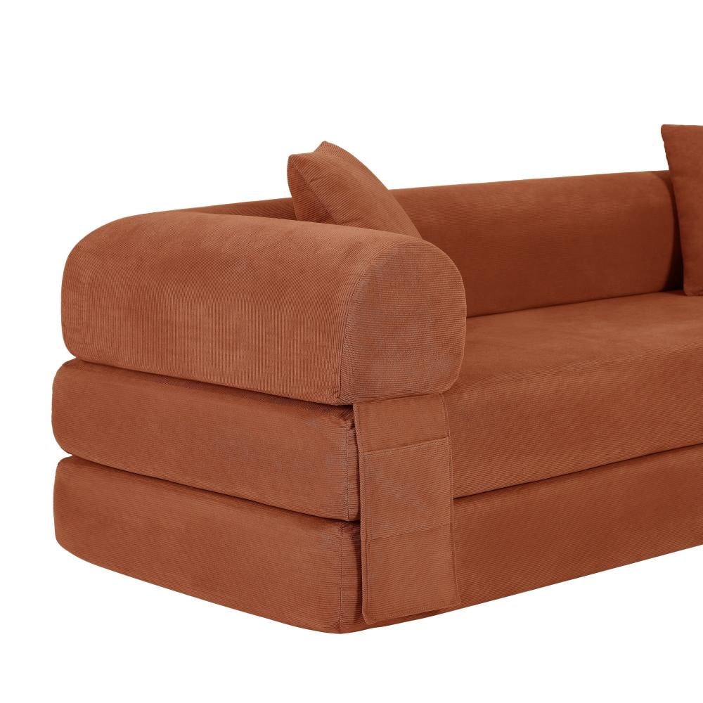 Close-up view of the rounded armrest and side of the orange corduroy sleeper sofa.