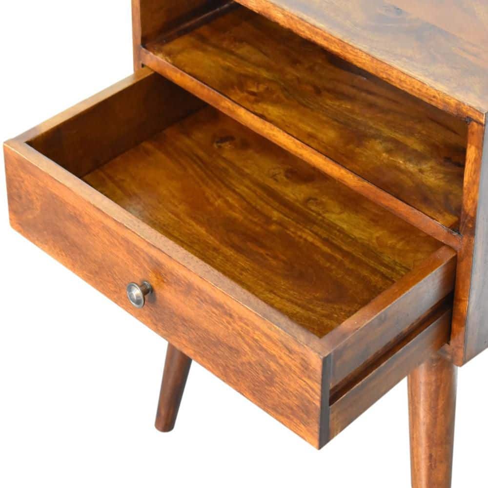 The drawer of the wooden nightstand is open.
