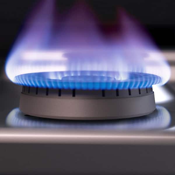 Stove closeup in modern kitchen interior with stainless steel gas cook-top.  Stock Photo