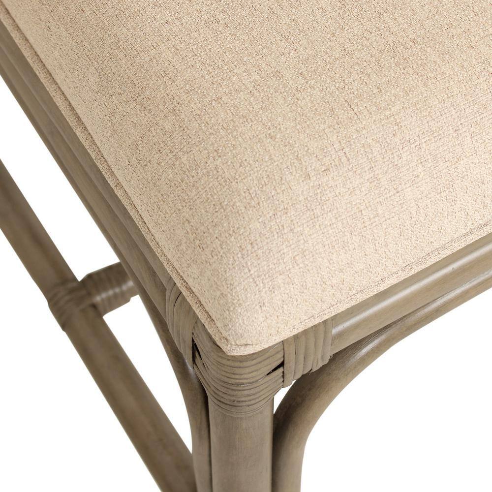 Close-up of the beige upholstered seat and rattan frame.