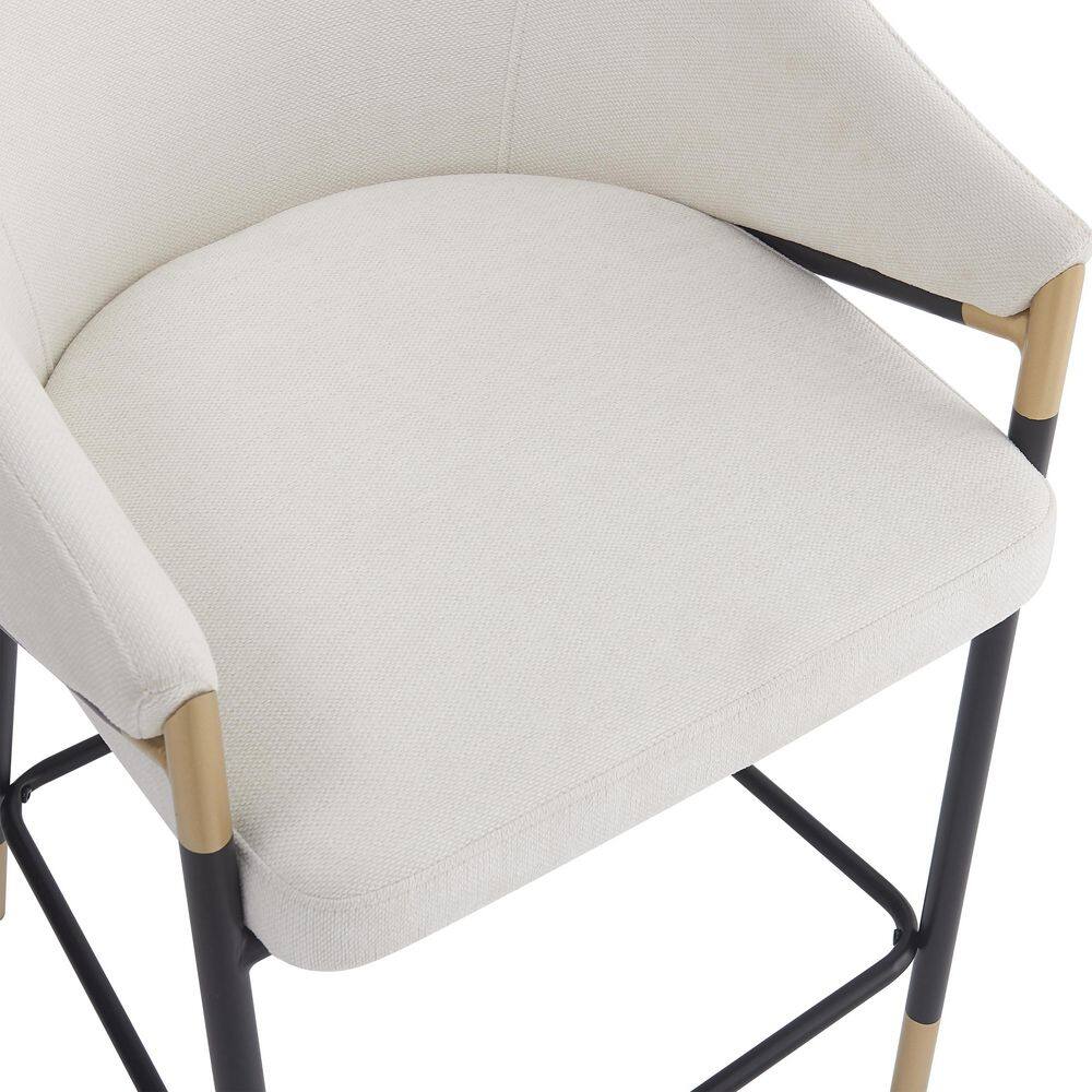 Top-down close-up of the beige upholstered seat and armrest of a bar stool.