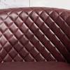 Close-up of diamond tufted red faux leather upholstery.