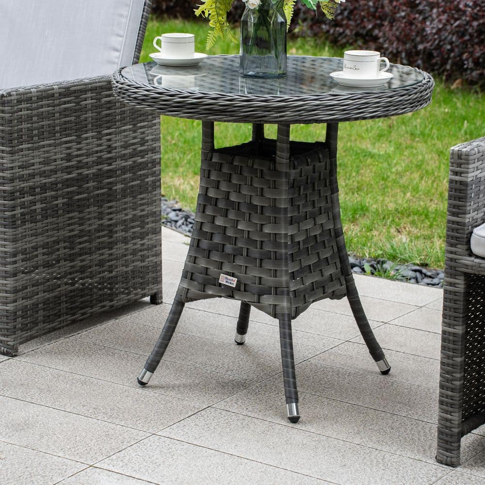 Close-up of the round glass-top bistro table with gray woven base.