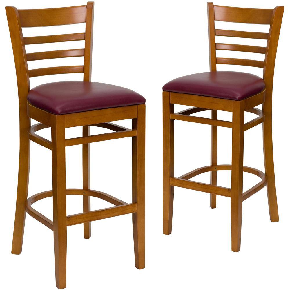 Two burgundy vinyl seat bar stools with cherry wood frames.