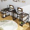Gray wood L-shaped desk in a home office setting with dual monitors and shelving.